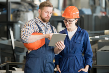 2 workers looking at a tablet