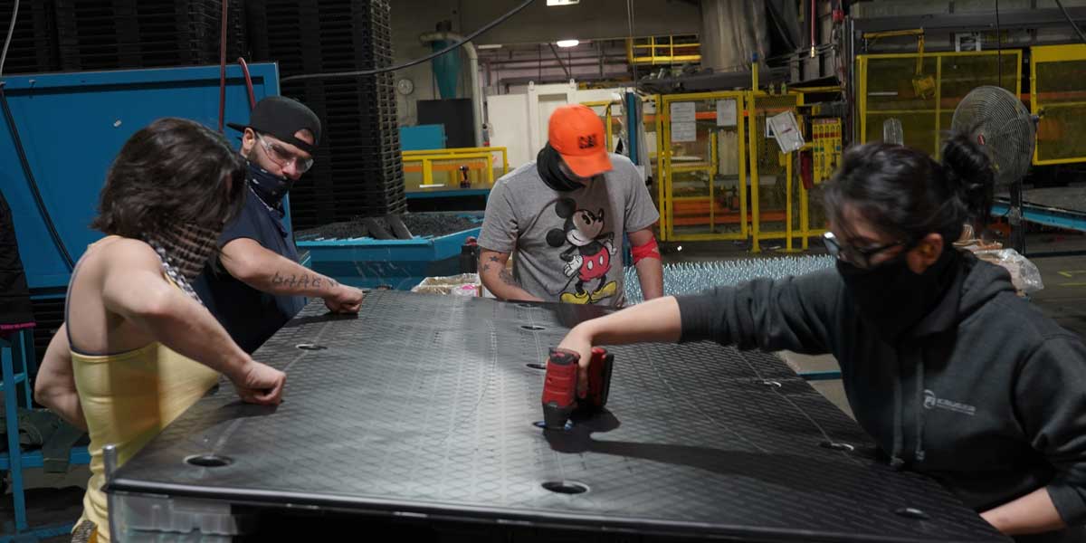 TriEnda employees working on a plastic pallet