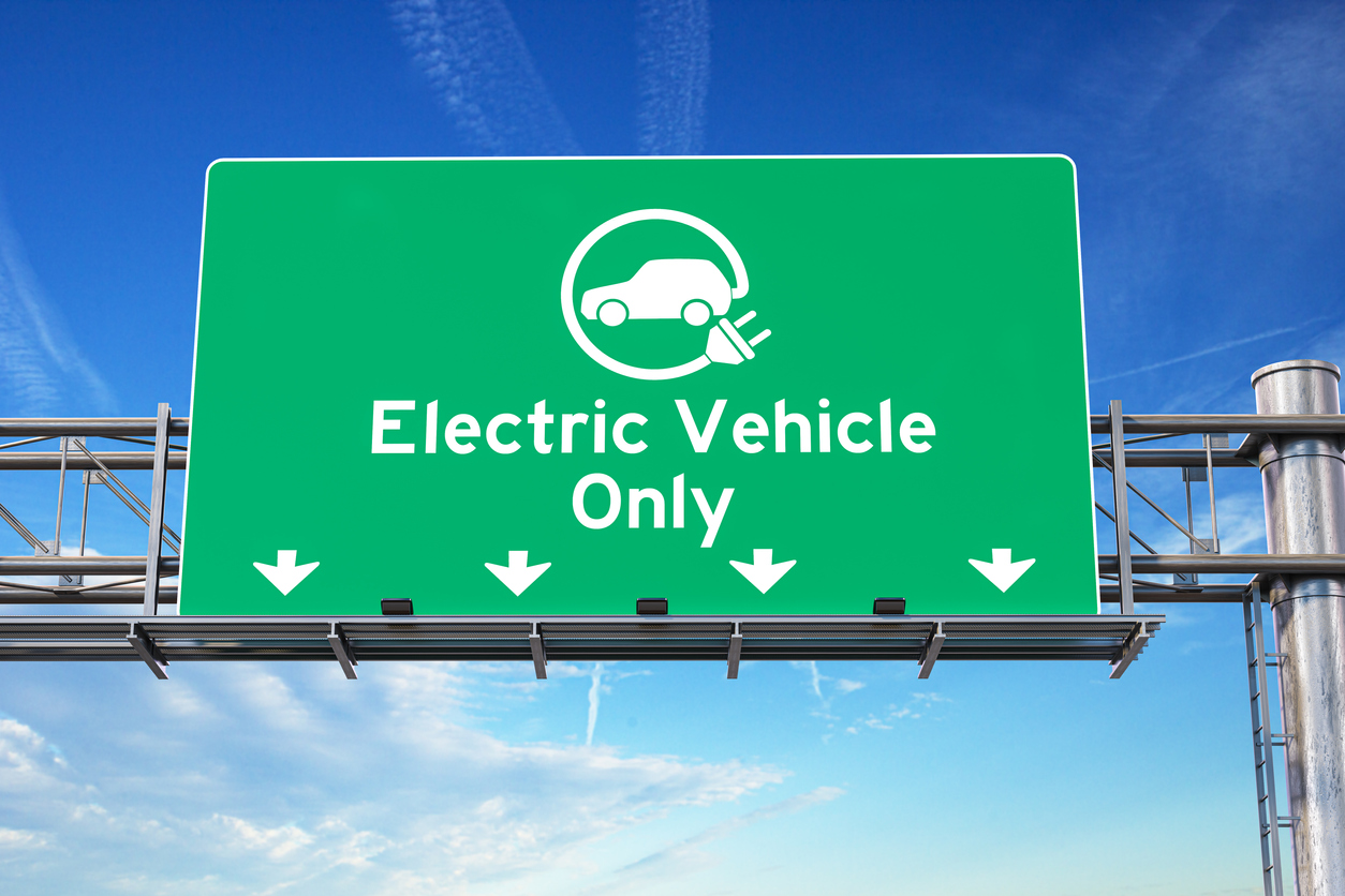 Electric vehicle only green traffic road sign.